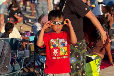 Un enfant regarde l'éclipse avec ses lunettes : un spectacle en toute sécurité. - Enlarge image 5 of 6, modal window